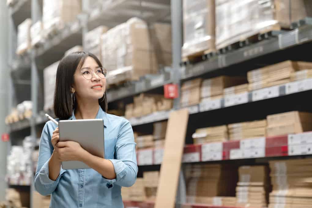 young woman in warehouse using inventory tracking system