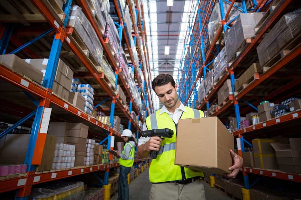Warehouse worker using rf scanner to pack inventory order
