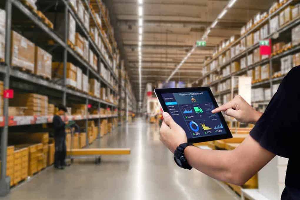 man using warehouse technology on his tablet in warehouse